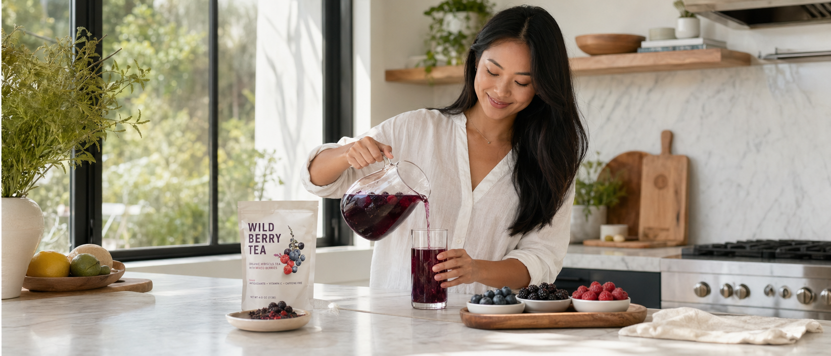 Woman pouring berry detox tea from pitcher in a bright modern kitchen